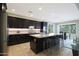 Modern kitchen with dark cabinets, granite island, and stainless steel appliances at 2005 N 169Th Ave, Goodyear, AZ 85395