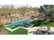 Inviting pool with travertine tile, surrounded by lush landscaping, overlooking a golf course at 2005 N 169Th Ave, Goodyear, AZ 85395