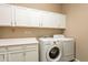 Laundry room with white cabinets and a washer and dryer at 22282 E Tierra Grande Ct, Queen Creek, AZ 85142