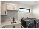 Laundry room with modern washer, dryer, and stylish tile at 2430 E Palo Verde Dr, Phoenix, AZ 85016