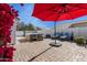 Landscaped backyard oasis with hot tub, patio furniture, and red umbrella at 24833 W Jessica Ln, Buckeye, AZ 85326