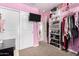 Pink bedroom with closet, shelving, and hanging clothes at 2731 W Wayland Dr, Phoenix, AZ 85041