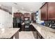 Modern kitchen with granite countertops and dark wood cabinets at 2731 W Wayland Dr, Phoenix, AZ 85041