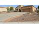 Front view of a charming home with a long driveway and desert landscaping at 28365 N 124Th Dr, Peoria, AZ 85383