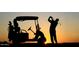 Golfer teeing off near golf cart at sunset at 28365 N 124Th Dr, Peoria, AZ 85383