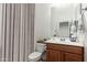 Neat bathroom with toilet and sink, cabinet, and a large curtain at 33612 N 24Th Dr, Phoenix, AZ 85085