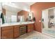 Double vanity bathroom with wood cabinets and a large mirror at 33612 N 24Th Dr, Phoenix, AZ 85085