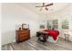 Bedroom with wood floors, red bedding, and a sewing machine at 33612 N 24Th Dr, Phoenix, AZ 85085