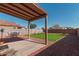 Covered patio, grassy area, and dining furniture in backyard at 36811 N El Morro Trl, San Tan Valley, AZ 85140