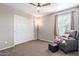 Bedroom with a ceiling fan, comfy armchair, and sliding door closet at 36811 N El Morro Trl, San Tan Valley, AZ 85140