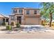 Two-story house with a beige exterior, two-car garage, and well-manicured landscaping at 36811 N El Morro Trl, San Tan Valley, AZ 85140