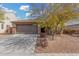 House exterior featuring a brown garage door, stone accents, and a well-manicured front yard at 3905 S 185Th Ln, Goodyear, AZ 85338