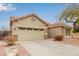 Tan house with a two-car garage and red flowers at 4170 E Winged Foot Pl, Chandler, AZ 85249