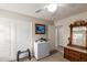 Well-lit bedroom with mini-fridge, dresser, and ample closet space at 42276 W Chisholm Dr, Maricopa, AZ 85138