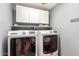 Laundry room with Maytag washer and dryer, cabinets, and shelving at 42276 W Chisholm Dr, Maricopa, AZ 85138