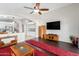 Living room features hardwood floors and a large TV at 42276 W Chisholm Dr, Maricopa, AZ 85138