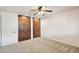 Bedroom with neutral carpet, ceiling fan, and dark wood closet doors at 43006 N 3Rd Ave, New River, AZ 85087