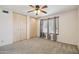 Bedroom featuring neutral carpet, ceiling fan, and light wood closet doors at 43006 N 3Rd Ave, New River, AZ 85087