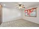 Bright bedroom featuring neutral carpet, ceiling fan and window with wood trim at 43006 N 3Rd Ave, New River, AZ 85087