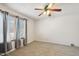 Bedroom with neutral carpet, ceiling fan, and window with patterned curtains at 43006 N 3Rd Ave, New River, AZ 85087