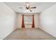 Bedroom featuring neutral carpet, ceiling fan and window with orange drapes at 43006 N 3Rd Ave, New River, AZ 85087