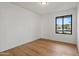 Simple bedroom with large window and hardwood floors at 4501 E Paradise Ln, Phoenix, AZ 85032