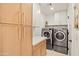 Laundry room with washer, dryer, and ample cabinet space at 4501 E Paradise Ln, Phoenix, AZ 85032