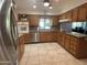 Open kitchen with wood cabinets, granite countertops, and stainless steel appliances at 4624 E Emerald Ave, Mesa, AZ 85206