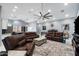 Living room with vaulted ceiling, brown leather couches, and ceiling fan at 5063 E Reavis St, Apache Junction, AZ 85119