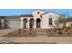 Front view of a single-story house with a gray garage door and arched entry at 5252 N 206Th Dr, Buckeye, AZ 85396