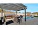 Outdoor kitchen with pergola, grill, and bar seating at 5252 N 206Th Dr, Buckeye, AZ 85396