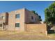 Side view of a two-story stucco building with a block wall at 600 S Dobson Rd # 166, Mesa, AZ 85202