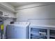 Bright laundry room with washer, dryer, and built-in shelving at 600 S Dobson Rd # 166, Mesa, AZ 85202