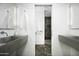 Modern bathroom featuring stone floors, double sinks, and view into the shower area at 6529 E Camino De Los Ranchos St, Scottsdale, AZ 85254