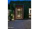 Exterior view of a unique entrance gate surrounded by lush greenery at night at 6529 E Camino De Los Ranchos St, Scottsdale, AZ 85254