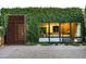 Exterior shot showcasing a home's unique window and a modern artistic metal screen covered in lush greenery at 6529 E Camino De Los Ranchos St, Scottsdale, AZ 85254