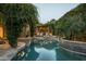 Beautiful backyard pool area featuring lush greenery, stone accents, and outdoor seating at 6529 E Camino De Los Ranchos St, Scottsdale, AZ 85254