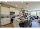 Modern kitchen features island with seating, stainless steel appliances, and light-colored cabinetry at 813 E Verde Blvd, Queen Creek, AZ 85140