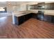 Modern kitchen with dark cabinetry, stainless steel appliances, and wood-look flooring at 8148 W Atlantis Way, Phoenix, AZ 85043