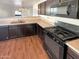 View of kitchen with dark cabinets, stainless steel appliances and wood-look flooring at 8148 W Atlantis Way, Phoenix, AZ 85043