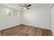 Simple bedroom with wood-look floors and a window with blinds at 8614 E Valley View Rd, Scottsdale, AZ 85250