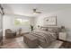 This is a stylish main bedroom with a comfortable bed, modern fan, bench, and a neutral color palette at 8614 E Valley View Rd, Scottsdale, AZ 85250