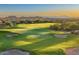 Aerial view of a golf course with mountain backdrop at sunset at 9505 E Superstition Mountain Dr, Gold Canyon, AZ 85118