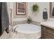 Round soaking tub with wood vanity and neutral tile flooring at 9505 E Superstition Mountain Dr, Gold Canyon, AZ 85118