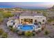 Aerial view of desert home highlighting an inviting pool with outdoor seating and desert landscaping at 9505 E Superstition Mountain Dr, Gold Canyon, AZ 85118