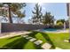 Artificial turf backyard with a kidney-shaped pool and stone pathway at 9745 E Natal Ave, Mesa, AZ 85209