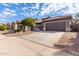 Front view of a house with a two-car garage and gravel driveway at 9745 E Natal Ave, Mesa, AZ 85209