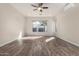 Living room with wood-look floors, large window, and ceiling fan at 9745 E Natal Ave, Mesa, AZ 85209