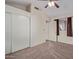 Bedroom with carpet, ceiling fan, and large mirrored closet at 10101 N 91St Ave # 136, Peoria, AZ 85345