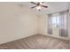 Bedroom with carpeted floor, ceiling fan, and window with curtains at 10101 N 91St Ave # 136, Peoria, AZ 85345